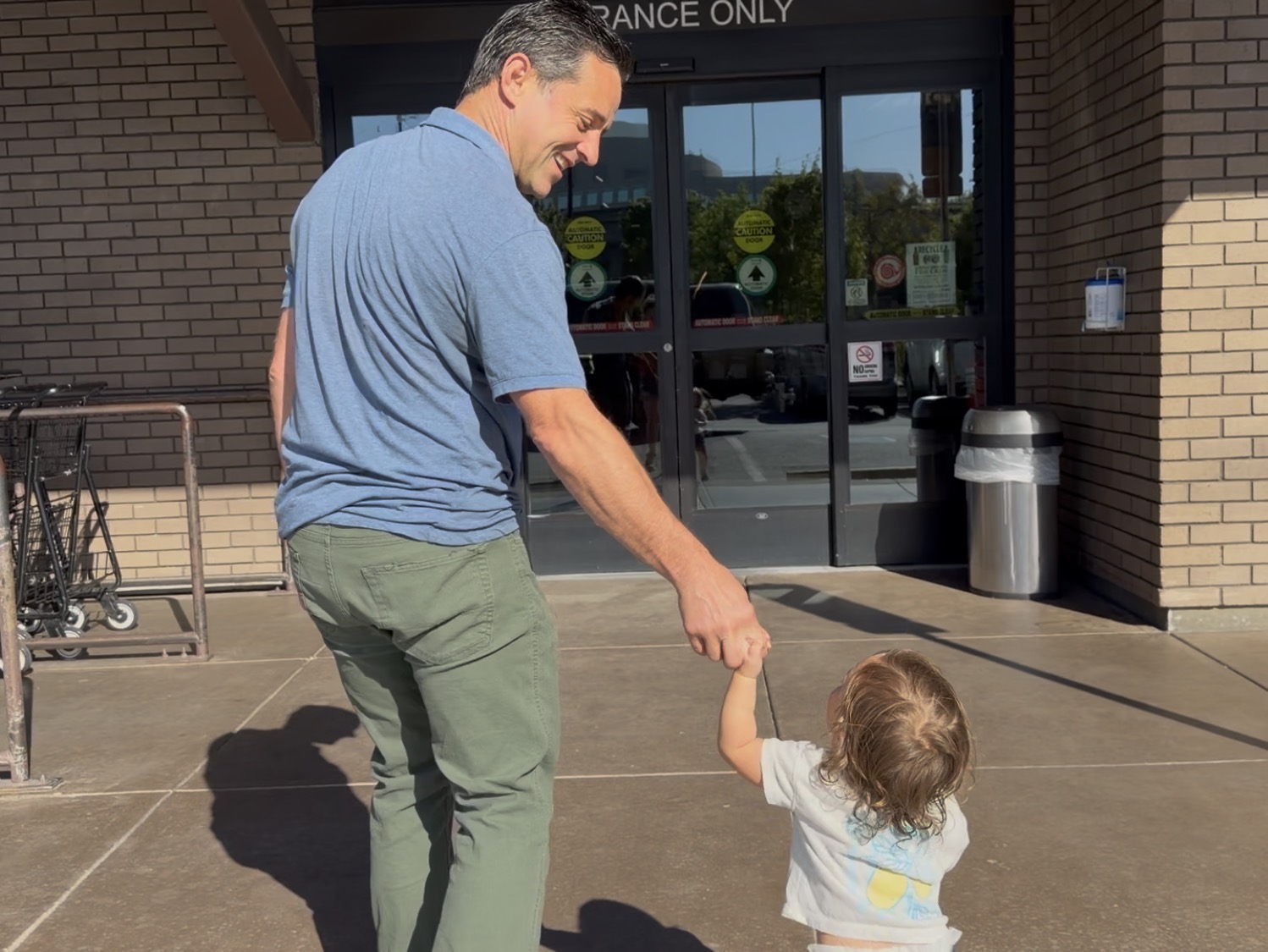 Ryan walking hand in hand with his daughter outside the Co-op